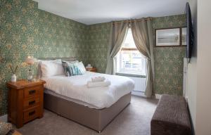 a bedroom with a bed and a window at The Crown in Poole