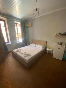 a bedroom with a large bed and two windows at spla apartments 3 , Διαμέρισμα στην πόλη των Χανίων in Chania Town