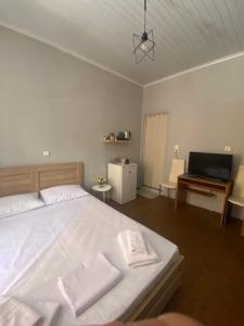 a bedroom with a large white bed and a television at spla apartments 3 , Διαμέρισμα στην πόλη των Χανίων in Chania Town