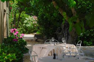a table with a white table cloth and chairs and flowers at Hôtel La Figuière in Saint-Tropez