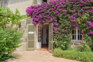 an entrance to a house with purple flowers at Hôtel La Figuière in Saint-Tropez