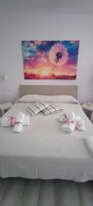 a white bed with towels and a painting on the wall at B&B PalmaViola in Caserta