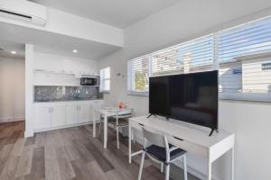 a kitchen with a white table and a large screen tv at Spacious studio with Balcony and Parking at the Beach -M46 in Hollywood