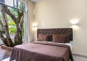 a bedroom with a large bed with a large window at Hotel Posada Campestre San Gil in San Gil