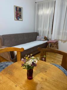 a living room with a table with a vase of flowers on it at Apartman Plužine in Plužine