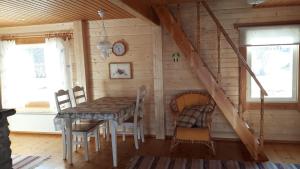 a dining room with a table and chairs in a cabin at Huvila Lahdenranta in Räyrinki