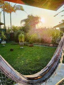 a hammock in a backyard with a yard at Pousada 4 Estações itapoa in Itapoa +14 photos