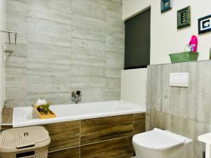 a bathroom with a tub and a toilet at Bright & Stylish Self Catering Swakopmund CBD in Swakopmund +108 photos
