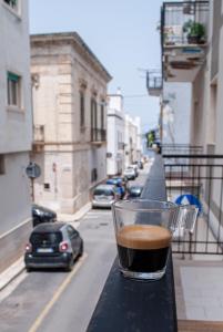 una tazza di caffè seduta su un tavolo sul balcone di My Apulian Home in Polignano a Mare a Polignano a Mare