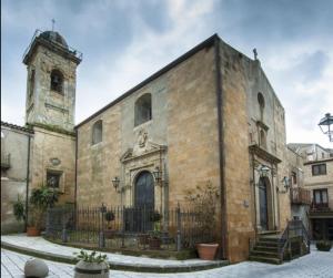 an old brick building with a tower and a church at Holiday Grivi in Enna