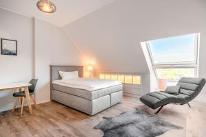 a bedroom with a bed and a chair and a desk at One Moment Boardinghouse - Porta Westfalica in Porta Westfalica