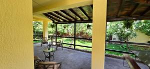 a screened in porch with chairs and tables and windows at La mama Miha in Agigea