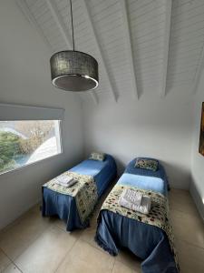ein Schlafzimmer mit zwei Betten und einem Fenster in der Unterkunft El Canelo in Villa La Angostura