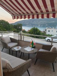 a patio with chairs and tables and a view of the water at ToplibregVilla in Herceg-Novi +17 photos