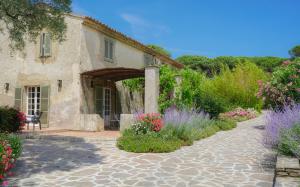 a house with a stone walkway and flowers in front at Hôtel La Figuière in Saint-Tropez