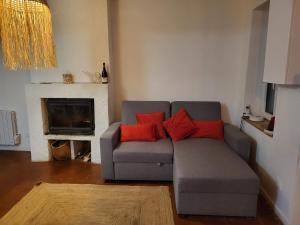 a living room with a gray couch with red pillows at blu dragonfly in Saint-Aubin-sur-Loire