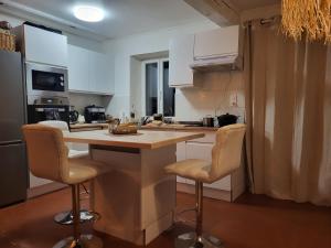 a kitchen with a counter and two bar stools at blu dragonfly in Saint-Aubin-sur-Loire