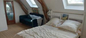 a bedroom with a bed and a blue chair at blu dragonfly in Saint-Aubin-sur-Loire