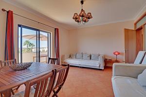 a living room with a table and a couch at Pêra Secret Garden 1 and Pool by Homing in Pêra