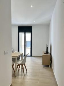 een eetkamer met een tafel en een tafel en stoelen bij Moderno apartamento con terraza en la azotea in Roses