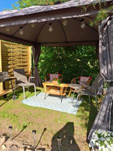 eine Terrasse mit Tisch und Stühlen unter einem Sonnenschirm in der Unterkunft Domeczek in Sulęczyno