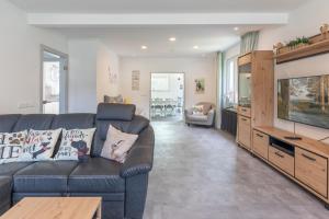 a living room with a couch and a flat screen tv at Dat witte Hus am Friedrichberg in Husum
