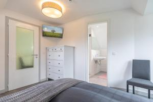 a bedroom with a bed and a chair and a sink at Dat witte Hus am Friedrichberg in Husum +46 photos