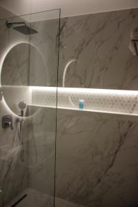 a bathroom with a shower with a glass door at Hotel Monarch in Elbasan