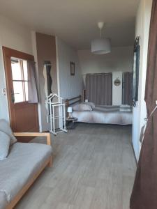 a living room with two beds and a couch at La Maison Genevier - Chambre Doréline in Montreuil-en-Touraine