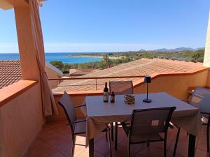 a table and chairs on a balcony with a view of the ocean at Villa Laura in Villaputzu