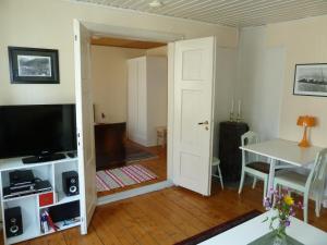 a living room with a television and a table at Red Old House Tromsø Apartment in Tromsø