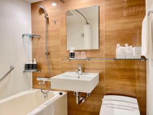 a bathroom with a sink and a toilet and a tub at The Kanzashi Tokyo Asakusa in Tokyo