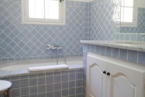 a blue bathroom with a tub and a sink at Hôtel La Figuière in Saint-Tropez