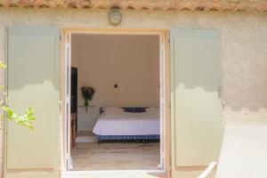 an open door to a bedroom with a bed at Hôtel La Figuière in Saint-Tropez