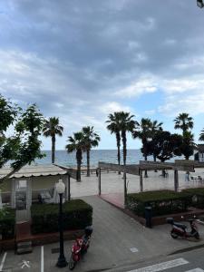 Blick auf einen Strand mit Palmen und Motorrädern in der Unterkunft ALQUILER PISO BLANES con VISTAS AL MAR in Blanes