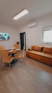 a living room with a couch and a table and chairs at Apartments ROKO in Izola
