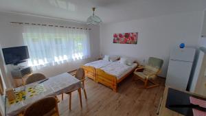 a small room with a bed and a table and chairs at Dom Colonia in Żarnowska