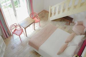 a bedroom with a bed and a table and chairs at Hôtel La Figuière in Saint-Tropez