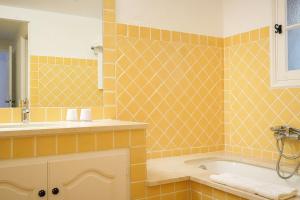 a bathroom with orange tiled walls and a tub at Hôtel La Figuière in Saint-Tropez
