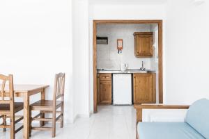 a kitchen with a table and a refrigerator at Apartamentos Balear Beach in Palmanova