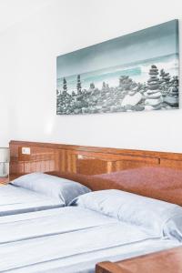 three beds in a room with a picture on the wall at Apartamentos Balear Beach in Palmanova