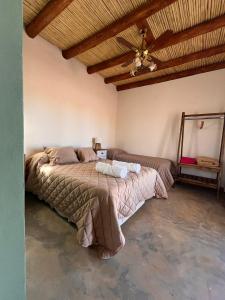 a bedroom with a large bed with a wooden ceiling at Posada Piuquén Suites De Montaña in Barreal