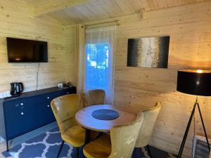 a room with a wooden wall with a table and chairs at Saulkrasti Beach Cottage in Saulkrasti