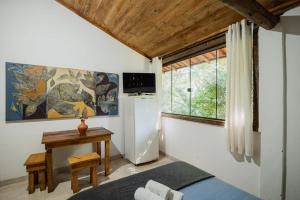 Camera con frigorifero, tavolo e finestra. di Pousada Passaredo a Brumadinho