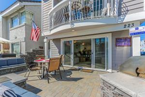 a patio with a table and chairs and a balcony at 3 Bedrooms in Newport Beach