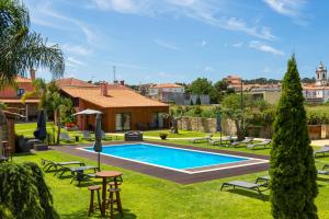 a pool in a yard with chairs and tables at Quercia Houses in Viana do Castelo in Viana do Castelo