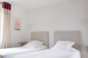 two beds sitting next to each other in a bedroom at Hôtel La Figuière in Saint-Tropez