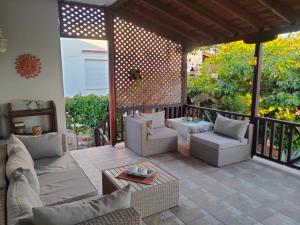 a patio with couches and chairs on a balcony at ESD House in Dhíkella
