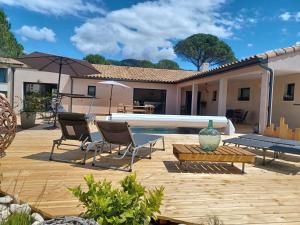 a patio with chairs and a table and a pool at Villa MOUREZEVA in Mourèze