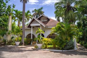 a house with palm trees in front of it at Merrils Beach Resort II in Negril